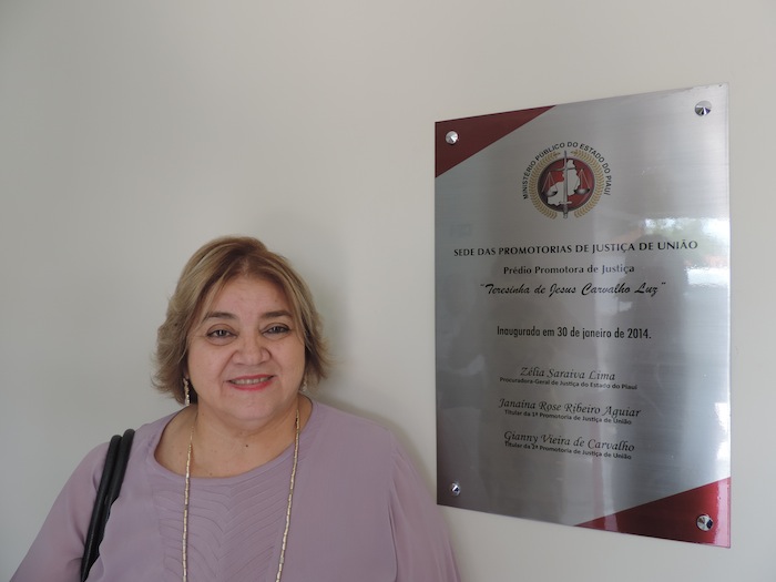 Zélia Saraiva Lima ao lado da placa de inauguração