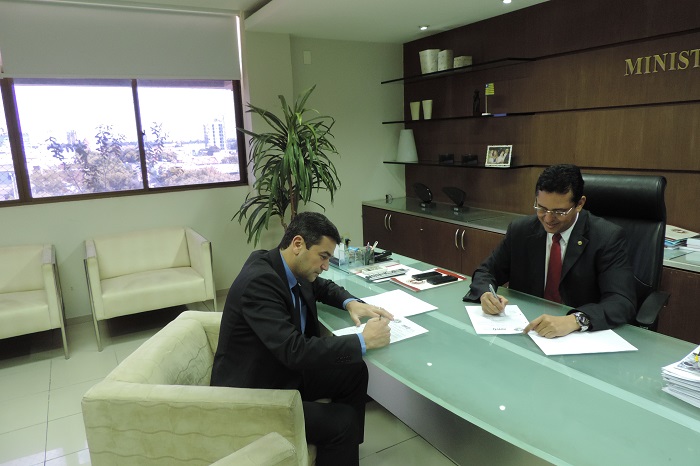 Procurador-Geral de Justiça Cleandro Moura e Leonardo Trigueiro, presidente da AMAPI sentados assinando Termo de Cooperação Técnica