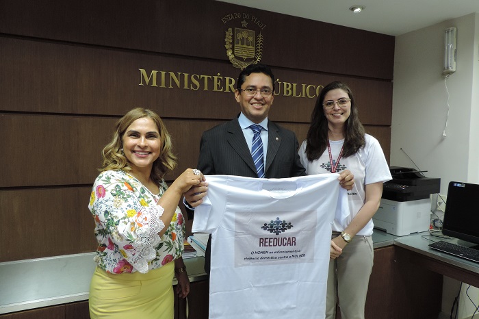 Procurador Geral de Justiça Clenadro Moura, Promotora Amparo Paz e a Psicóloga Cynara Veras segurando camisa do projeto 