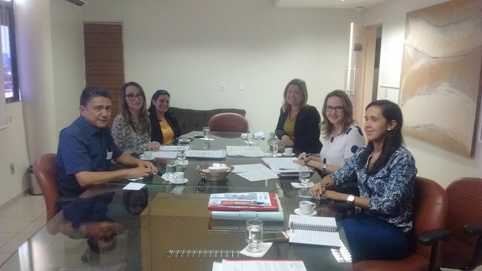 Foto: pessoas reunidas em torno de uma mesa.