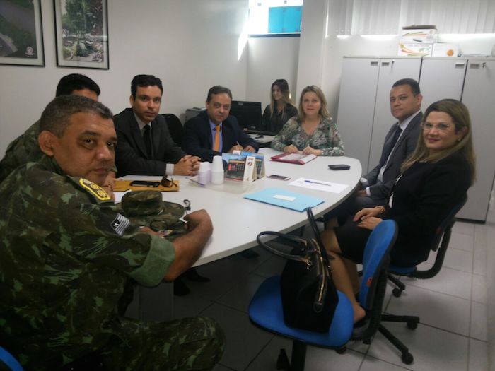 Foto: pessoas reunidas em torno de uma mesa.