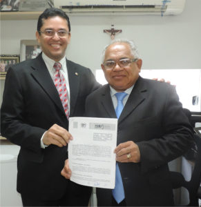 Procurador-Geral de Justiça e Diretor da EJUD mostram termo de cooperação assinado.