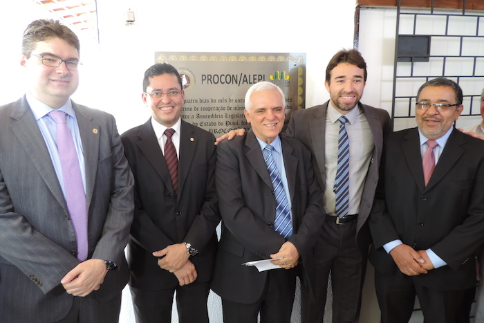 O Procurador Geral de Justiça, Cleandro Alves de Moura, posa com diversas outras autoridades na frente da placa de inauguração do novo PROCON