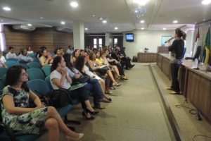 Pessoas de pé e pessoas sentadas assistindo palestra