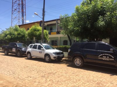 Carros parados em frente a um prédio.