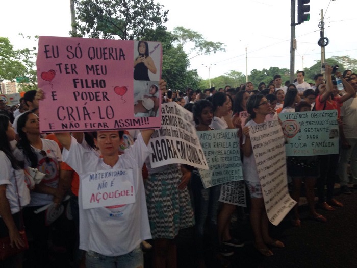Pessoas de pé segurando cartazes