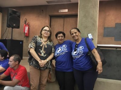 Três mulheres de pé sorrindo para foto