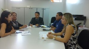 Pessoas reunidas ao redor de uma mesa discutindo em reunião