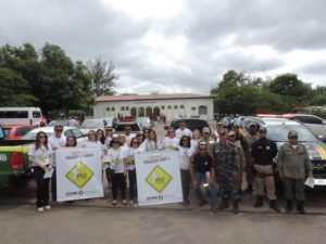 Pessoas de pé sorrindo segurando cartazes da caravana