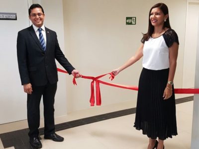 Procurador-Geral de Justiça e Procuradora-Chefe da PRT estão segurando as extremidades de um laço inaugural vermelho, prestes a desenlaçá-lo, dentro da nova sede em Bom Jesus.