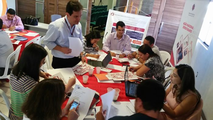 Pessoas trabalhando em torno de uma mesa.
