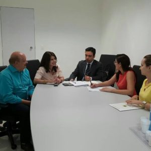 Cinco pessoas reunidas em torno de uma mesa.