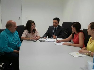 Cinco pessoas reunidas em torno de uma mesa.