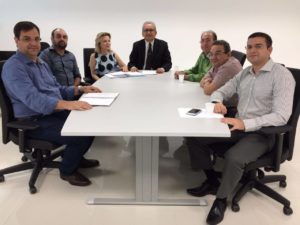 Pessoas sentadas em torno de uma mesa.