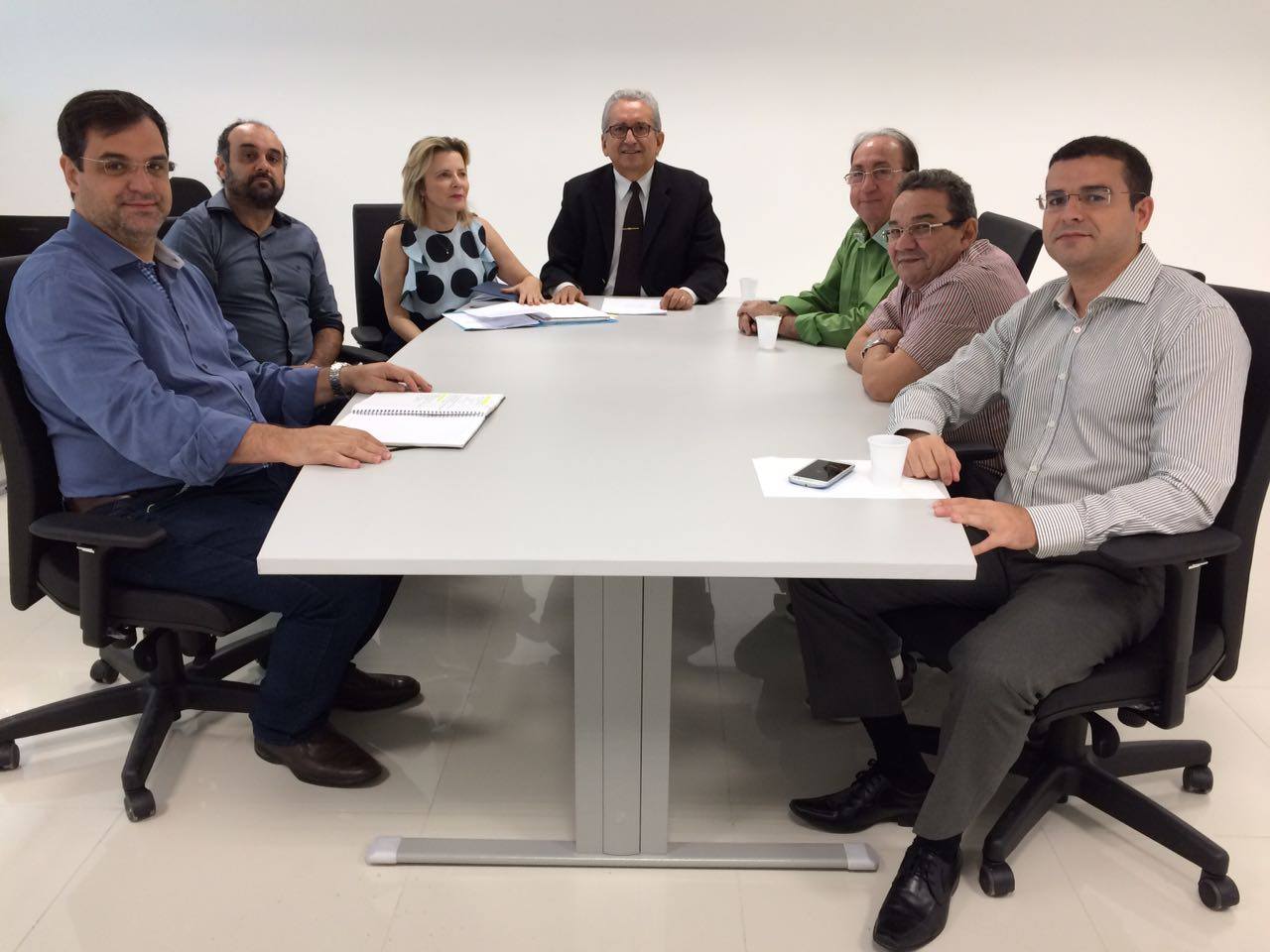 Pessoas sentadas em torno de uma mesa.