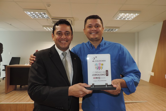 Dois homens segurando troféu e sorrindo para foto