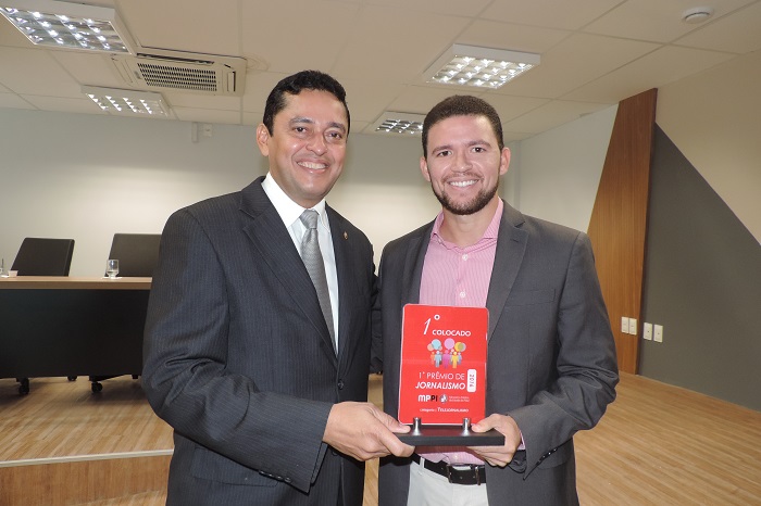 Dois homens segurando troféu e sorrindo 