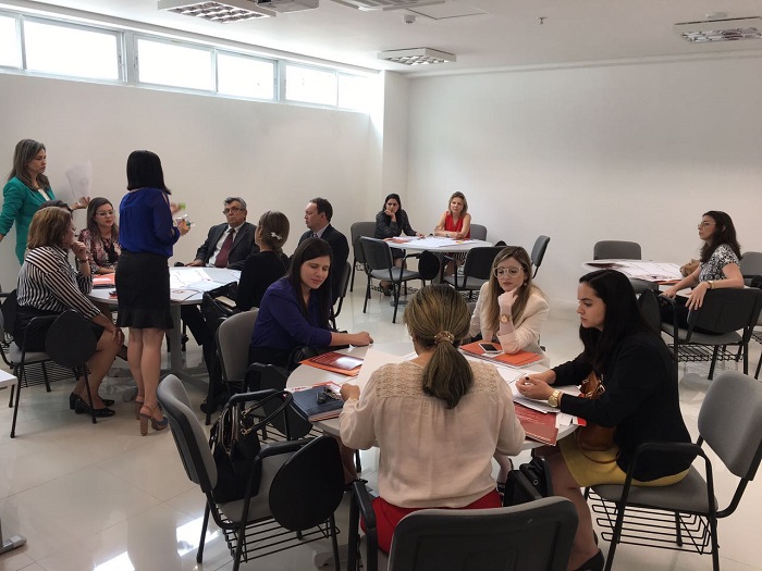 Pessoas sentadas em volta de várias mesas discutindo assuntos