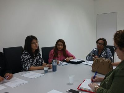 Pessoas sentadas em volta de uma mesa em discussão