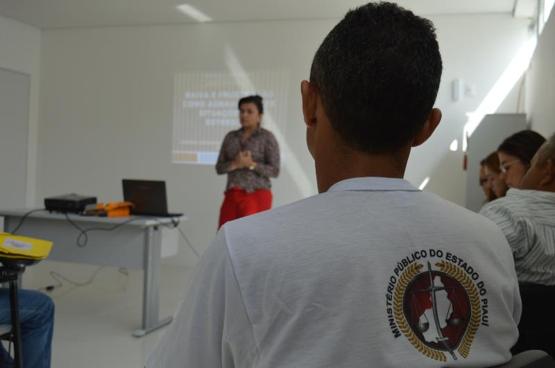 Pessoa sentada com outra ao fundo falando durante curso