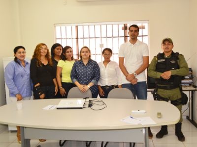 Pessoas em pé, posando diante de uma mesa.