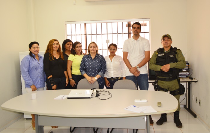 Pessoas em pé, posando diante de uma mesa.
