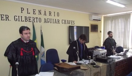 Promotor de Justiça de pé, com as vestes talares do Ministério Público, em sessão de júri.