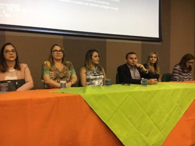 Pessoas sentadas junto a uma mesa de honra.