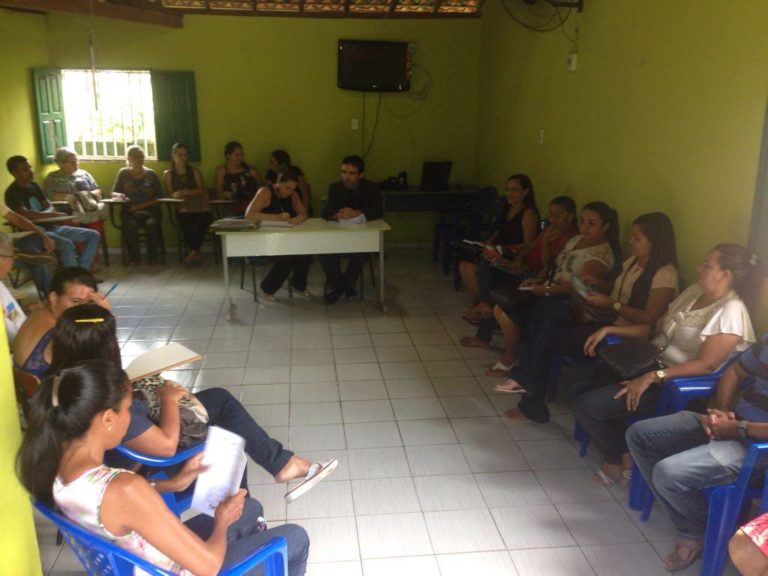 Muitas pessoas reunidas, sentadas em uma sala.
