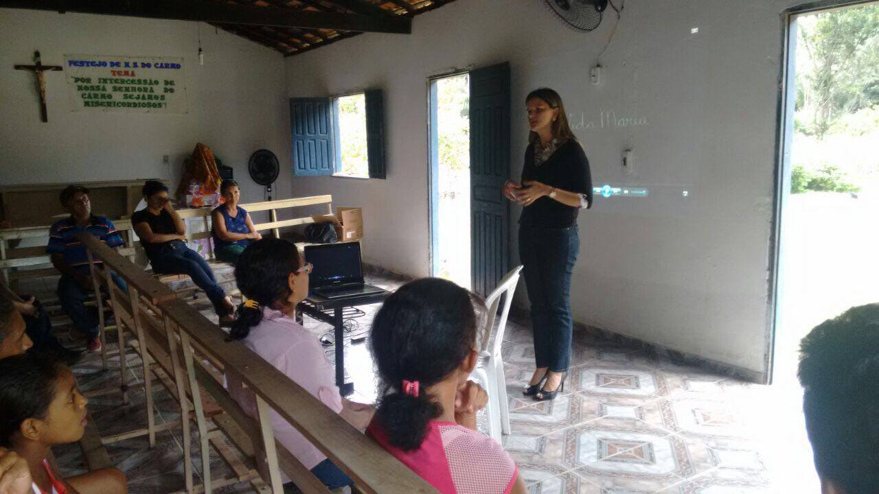 Promotora de Justiça em reunião com pais de alunos na igreja da comunidade.