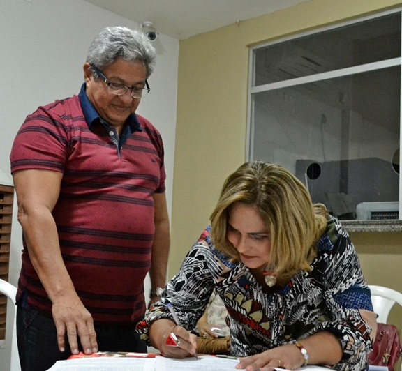 A Promotora de Justiça Amparo Paz assinando um documento.