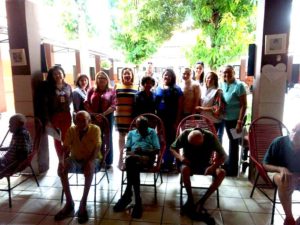 Promotoras de Justiça de pé, ao lado de idosos e da equipe do Abrigo São Lucas.