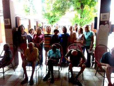 Promotoras de Justiça de pé, ao lado de idosos e da equipe do Abrigo São Lucas.