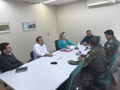 Seis pessoas reunidas em torno de uma mesa. Uma delas é a Promotora de Justiça Maria Eugênia Gonçalves Bastos.