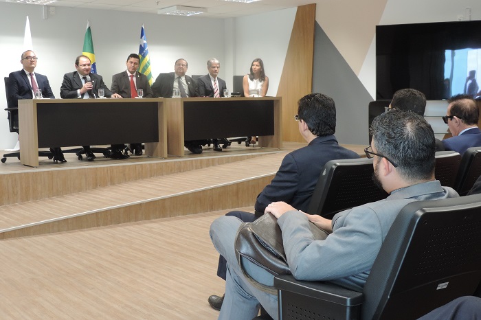 Homem observando a mesa composta por autoridades 