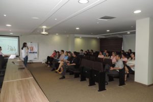 Palestrante fala para a plateia no auditório.