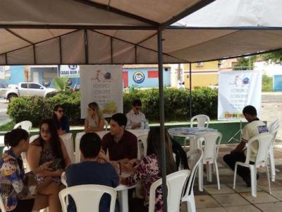 Estandes montados em praça, com várias pessoas sendo atendidas.