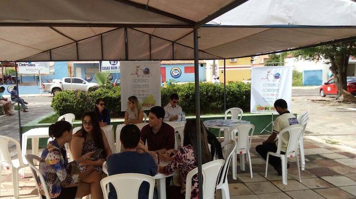 Estandes montados em praça, com várias pessoas sendo atendidas.