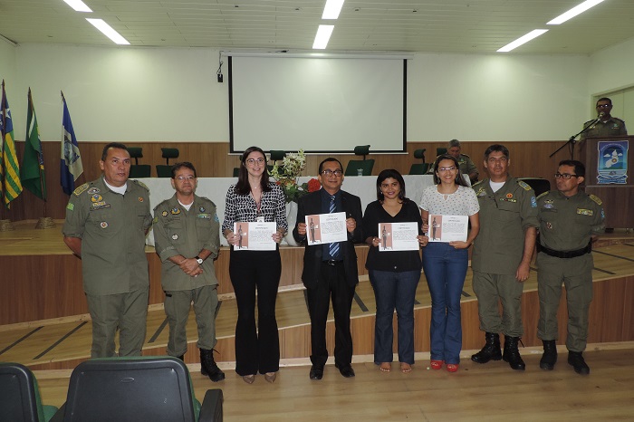 Pessoas de pé segurando um certificado