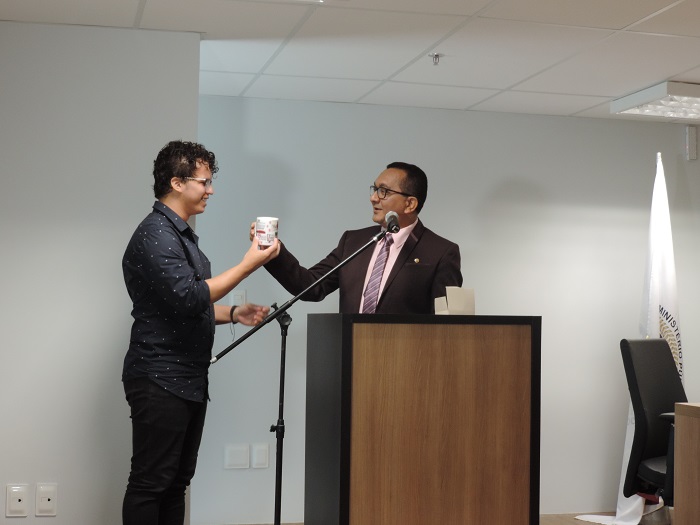 Homem entregando caneca para outro 