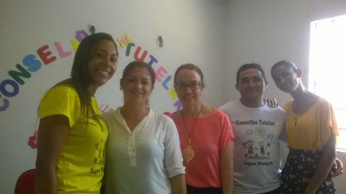 Promotora de Justiça posa de pé com adolescentes.