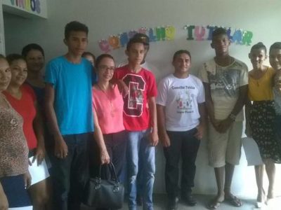 Promotora de Justiça posa de pé com adolescentes.