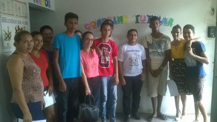 Promotora de Justiça posa de pé com adolescentes.