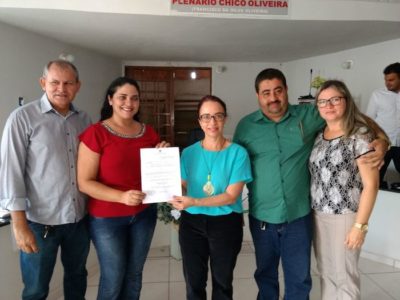 Pessoas em pé, segurando um certificado.