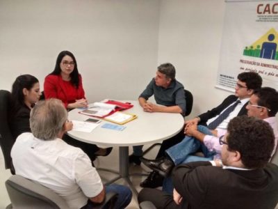 Pessoas sentadas em torno de uma mesa de reuniões.