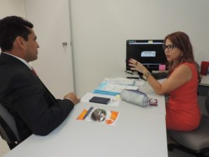 Promotora de Justiça Denise Aguiar diante do computador, ao lado do Procurador-Geral de Justiça. Na tela do computador, pode se ler