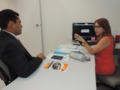 Promotora de Justiça Denise Aguiar diante do computador, ao lado do Procurador-Geral de Justiça. Na tela do computador, pode se ler