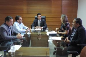 Pessoas sentada numa mesa durante reunião
