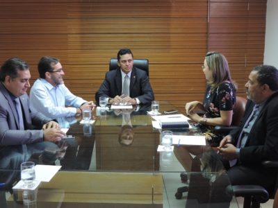 Pessoas sentada numa mesa durante reunião