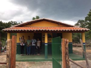 Promotora de Justiça e equipe de inspeção na frente de novo prédio de escola.